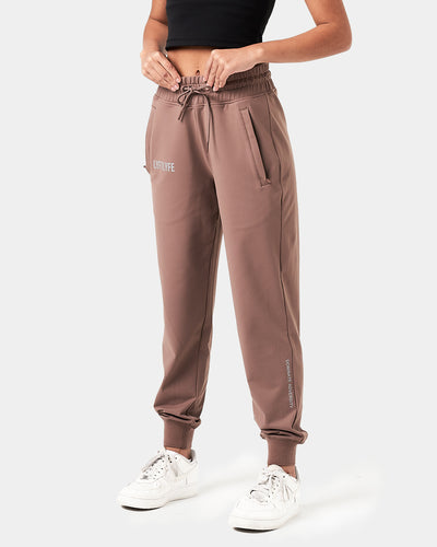 Women’s Breathe Joggers in brown, featuring a minimalist reflective Lyftlyfe logo, thick waistband, and a tapered fit for a flattering silhouette.