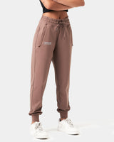 Side view of Women’s lightweight joggers in brown,  highlighting moisture-wicking fabric, thick waistband, and ergonomic fit for comfort.