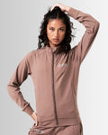 Front view of women’s Breathe Zip-Up Jacket in brown featuring a minimalist reflective Lyftlyfe logo on the left chest and a streamlined, athletic fit.