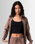 Women's performance zip-up jacket in brown, crafted from moisture-wicking, lightweight fabric for mobility.