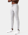 Side view of men’s Breathe Joggers in light gret featuring the slogan 'Dominate Adversity' on the lower left leg and secure zippered pockets.