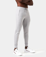 Right side view of light grey men’s joggers with a reflective logo near the pocket and stretch fabric for optimal movement.