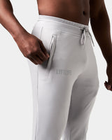 Close-up of the Lyftlyfe reflective logo on the right pocket of men’s light grey Breathe Joggers with tonal stitching.