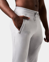 Detailed view of the Lyftlyfe reflective logo on the right pocket of men’s light grey Breathe Joggers with tonal stitching.