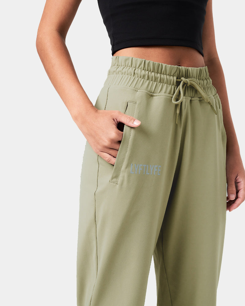 Detailed view of the ergonomic pocket placement on green women’s joggers with premium lightweight fabric.