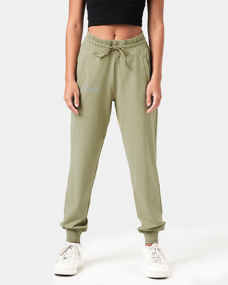 Front view of women’s green Breathe Joggers with a reflective Lyftlyfe logo, thick waistband, and tapered fit for a flattering look.