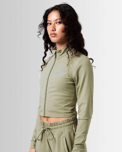 Front view of Breathe Women’s Zip-Up Crop in green with a reflective Lyftlyfe logo on the left chest and a flattering cropped fit.