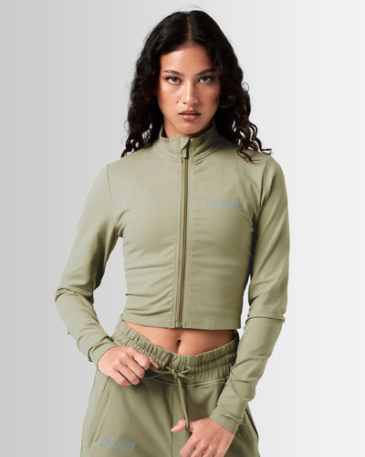 Front view of Breathe Women’s Zip-Up Crop in green with a reflective Lyftlyfe logo on the left chest and a flattering cropped fit.