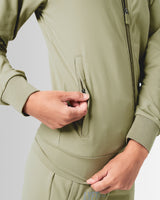Close-up of the pocket detailing on women’s athletic jacket in green with lightweight moisture-wicking fabric.
