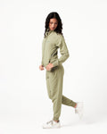 Side angle of women’s breathable joggers in green with reflective slogan and sleek tonal stitching.