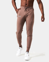 Men’s brown Breathe Joggers with a minimalist reflective logo near the pocket, wide waistband, and tonal drawstring.