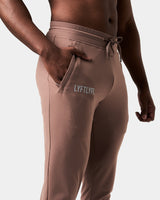 Close-up of men’s brown Breathe Joggers, highlighting the invisible side pocket with locking zipper and Lyftlyfe reflective logo.