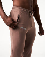 Close-up of men’s brown Breathe Joggers, highlighting the invisible side pocket with locking zipper and Lyftlyfe reflective logo.