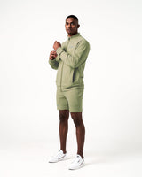 Side angle of green men’s athletic jacket with secure invisible pocket, locking zipper, and minimalist reflective branding.