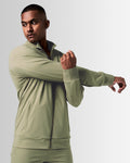 Side view of men’s green Breathe Zip-Up Jacket with ergonomic fit, wide cuffs, and lightweight stretch fabric for unrestricted movement.