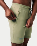 Close-up ofgreen Breathe Shorts with reflective branding and ergonomic waistband design for comfort.