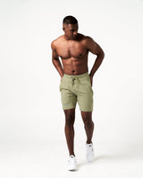 Men’s green lightweight performance shorts with secure invisible pockets, wide waistband, and reflective branding.