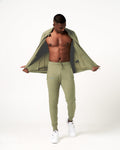 Men’s breathable joggers in green with a cuffed hem, reflective logo, and adjustable waistband.