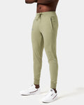 Side view of men’s Breathe Joggers in green featuring the slogan 'Dominate Adversity' on the lower left leg and secure zippered pockets.
