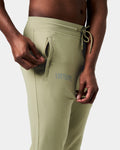 Detailed view of the Lyftlyfe reflective logo on the right pocket of men’s green Breathe Joggers with tonal stitching.