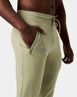 Close-up of the Lyftlyfe reflective logo on the right pocket of men’s green Breathe Joggers with tonal stitching.