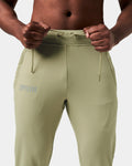 Close-up of green Breathe Joggers, showing elastic waistband, tonal drawstring, and Lyftlyfe reflective logo on the left thigh.