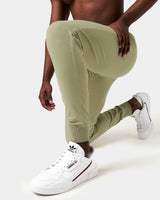 Detailed shot of the 'Dominate Adversity' slogan printed on the lower left leg of men’s black Breathe Joggers.