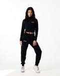 Women’s black cropped performance zip-up, designed with 4-way stretch fabric, custom zipper, and moisture-wicking properties.