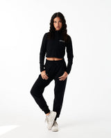 Women’s black cropped performance zip-up, designed with 4-way stretch fabric, custom zipper, and moisture-wicking properties.