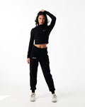 Black cropped performance jacket for women, highlighting reflective branding, shaping fit, and premium breathable fabric.