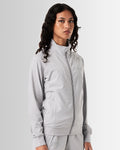 Left side view of light grey women’s breathable zip-up jacket highlighting its ergonomic design and reflective branding.
