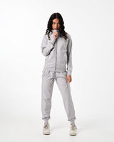 Women’s light grey performance jacket with moisture-wicking fabric and reflective branding. 