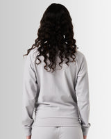 Back view of Women’s Breathe Zip-Up Jacket in light grey, with a sleek fit and reflective branding.