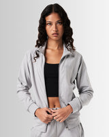 Women’s Breathe Zip-Up Jacket in light grey, designed for performance with a sleek fit and reflective branding.