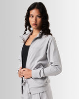 Women’s performance zip-up jacket, side profile showcasing breathable material and functional locking zipper pockets.