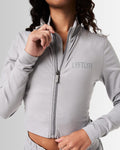 Detailed shot of the zipper design on women’s light grey cropped performance jacket, showcasing technical craftsmanship.