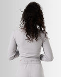 Back view of the cropped light grey zip-up for women, highlighting its tailored design and lightweight construction.