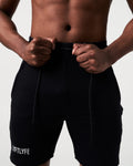 Detailed view of men’s black performance shorts showcasing the tonal drawstring and wide elastic waistband.