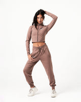 Women’s athletic crop zip-up in brown, showcasing sleek design and tailored fit for unrestricted movement.