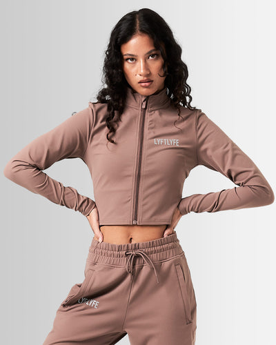 Women’s athletic crop zip-up in brown, showcasing sleek design and tailored fit for unrestricted movement.