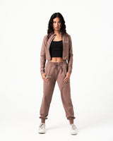 Brown cropped performance jacket for women, highlighting reflective branding, shaping fit, and premium breathable fabric.