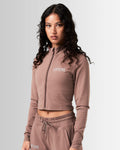 Left Side view of the Breathe Women’s Zip-Up Crop in brown highlighting the ergonomic fit, custom zipper closure, and breathable fabric.