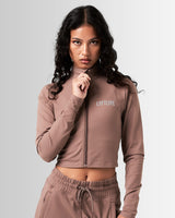 Front profile of the Breathe Women’s Zip-Up Crop in brown, featuring lightweight fabric and a flattering cropped design.