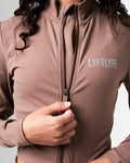 Detailed shot of the zipper design on women’s brown cropped performance jacket, showcasing technical craftsmanship.