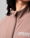 Close-up of the custom zipper closure and head cover on women’s Breathe Zip-Up Jacket in brown, highlighting premium stitching and technical design.