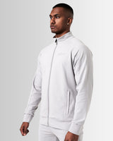 Left side view of light grey men’s athletic jacket with secure invisible pocket, locking zipper, and minimalist reflective branding.