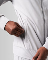 Close-up of the invisible pocket detailing on men’s athletic jacket in light grey with sweat-wicking properties and minimalist design.