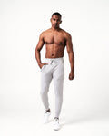 Men’s breathable joggers in light grey with a cuffed hem, reflective logo, and adjustable waistband.