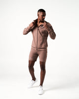 Men’s lightweight zip-up jacket in brown with moisture-wicking fabric, 4-way stretch, and ergonomic design for optimal performance.