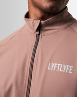 Detailed shot of the neck and zipper design on men’s brown performance jacket with lightweight breathable fabric.
